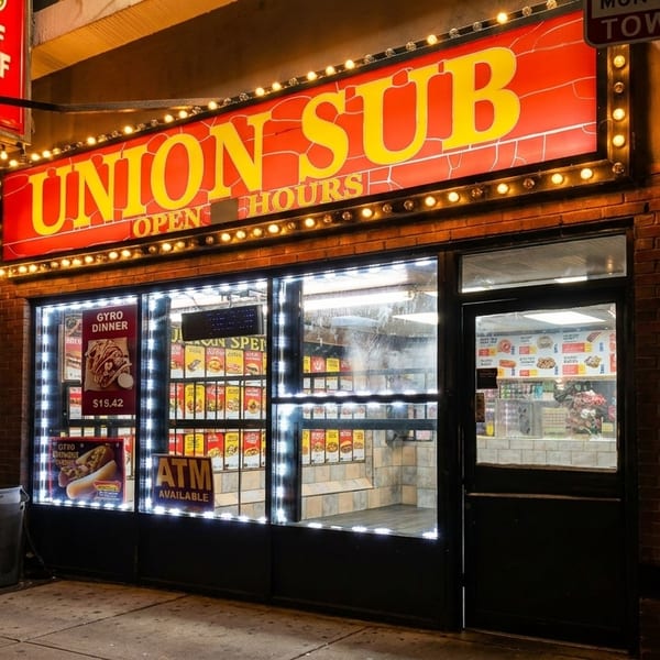 The brightly lit exterior of Union Sub restaurant at night, featuring a large red and yellow sign.